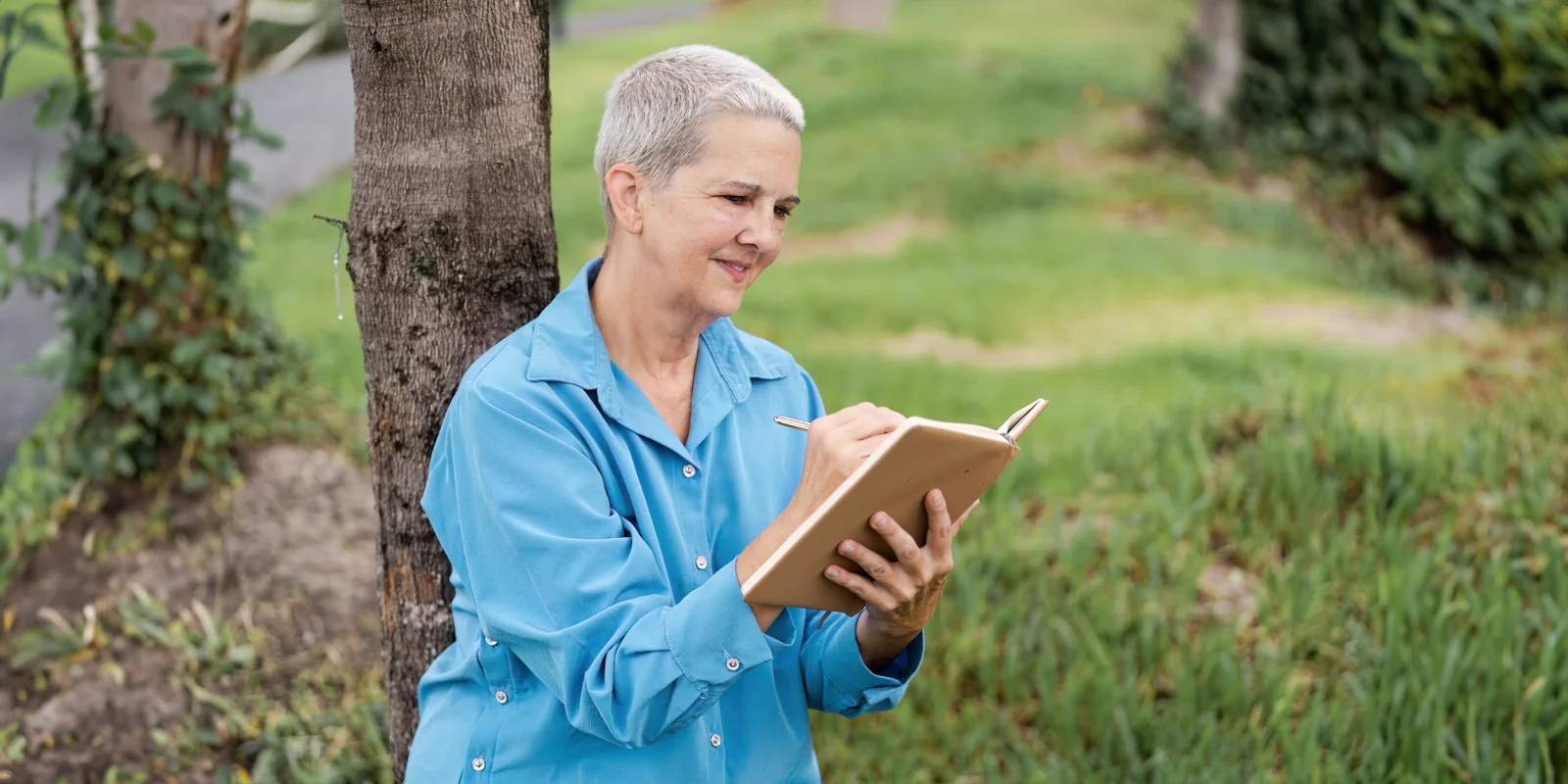 Senior Woman Writing in a Notebook Outdoors