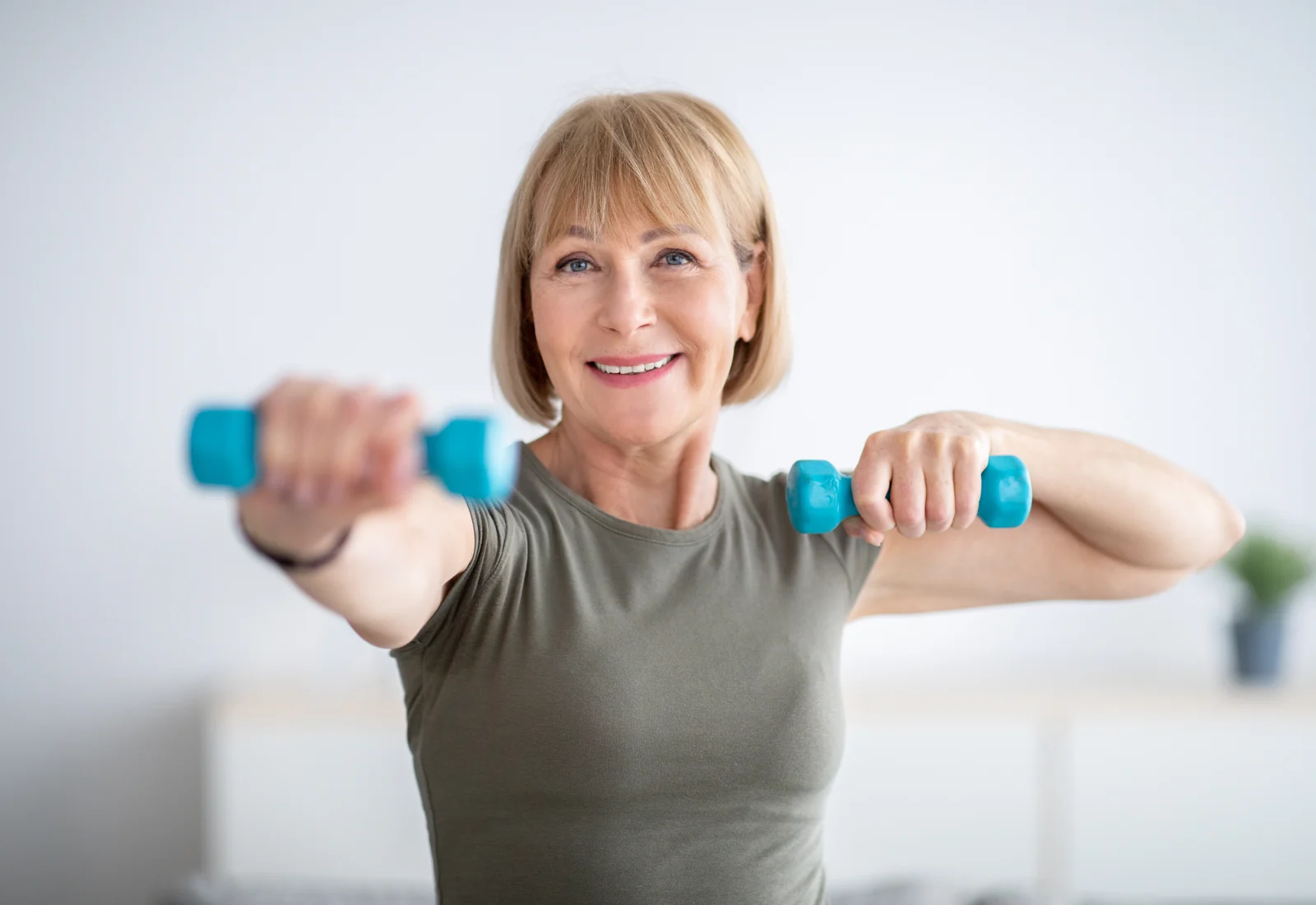 Smiling Woman Exercising at Home with Dumbbells