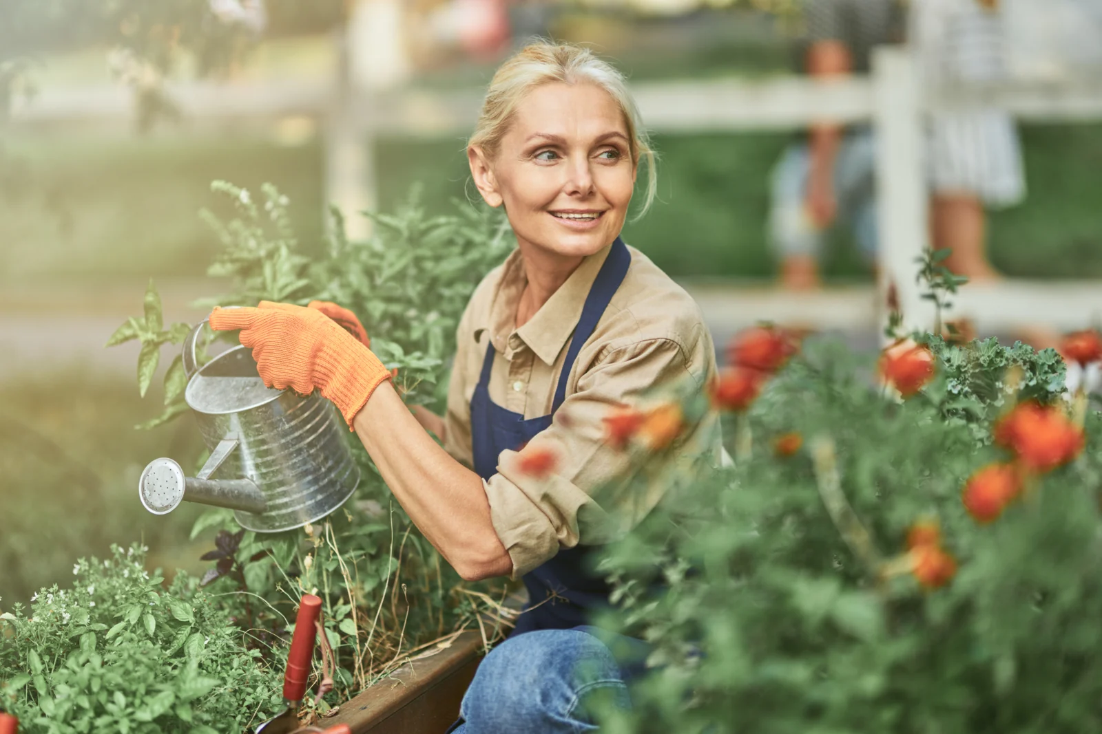 Woman Gardening and Watering Plants in Her Yard